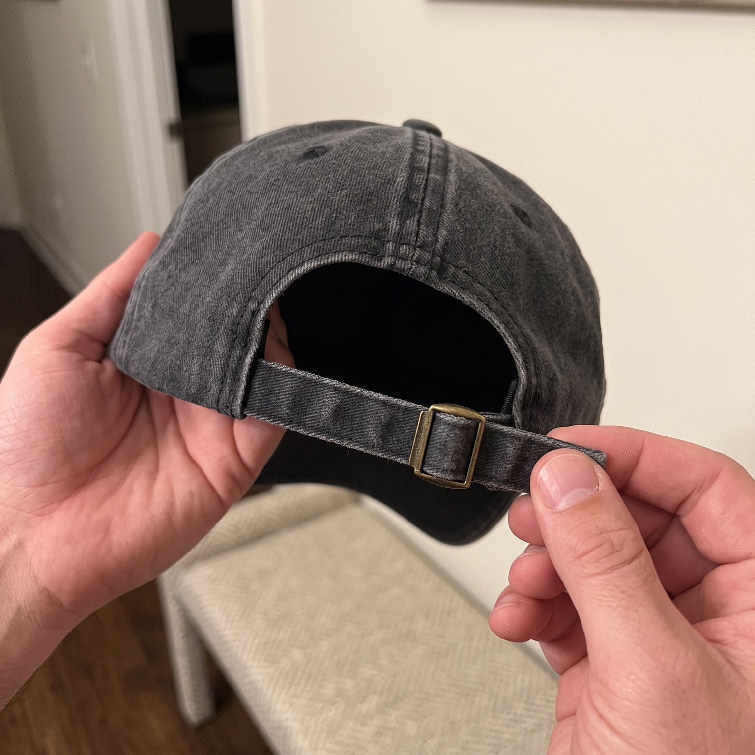 Close view of the adjustable back strap and brass slider on a Black cap