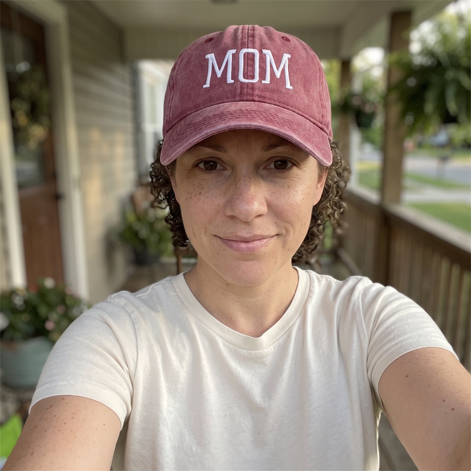 Mum taking a porch selfie in her Red MOM cap