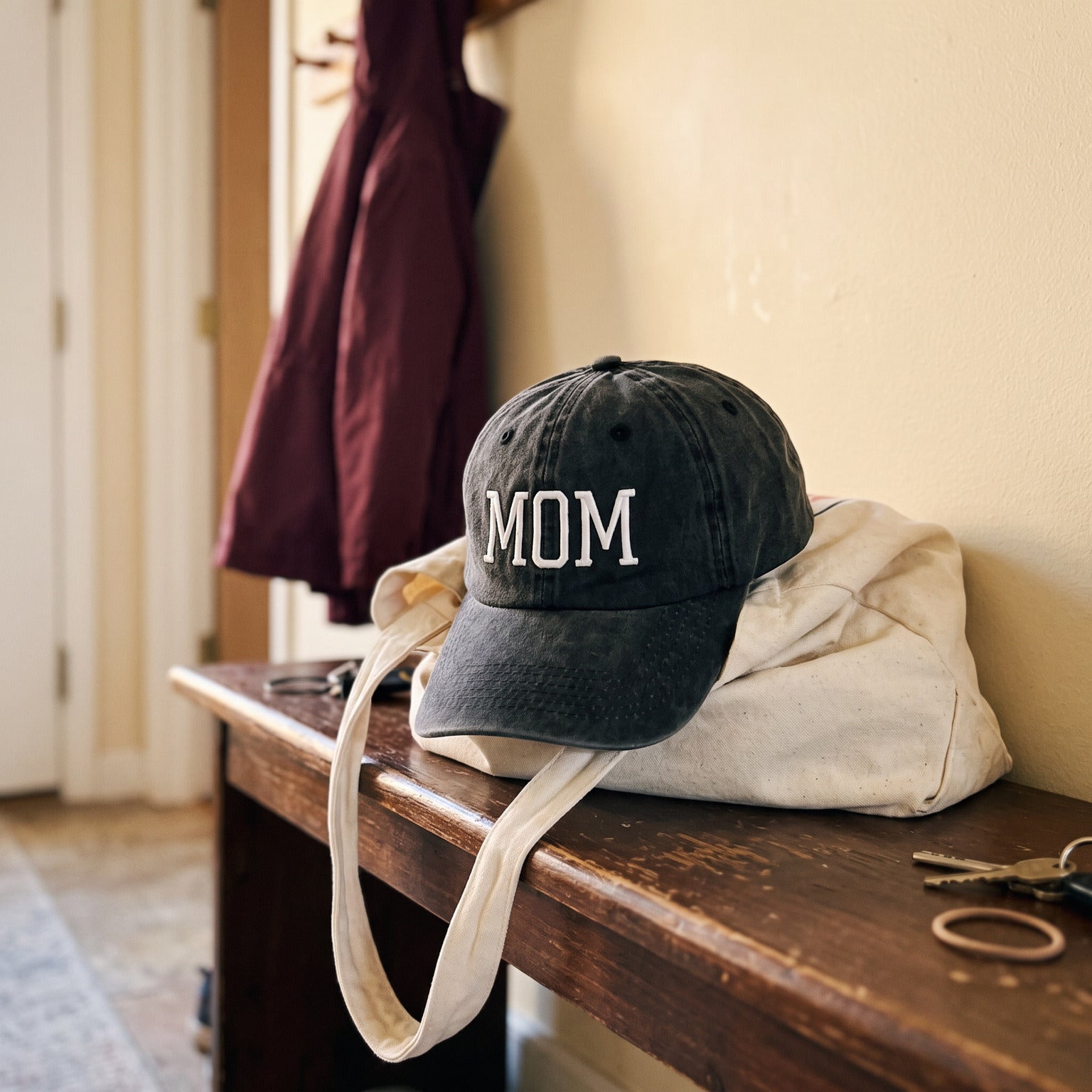 Black MOM cap on a bench after school pickup