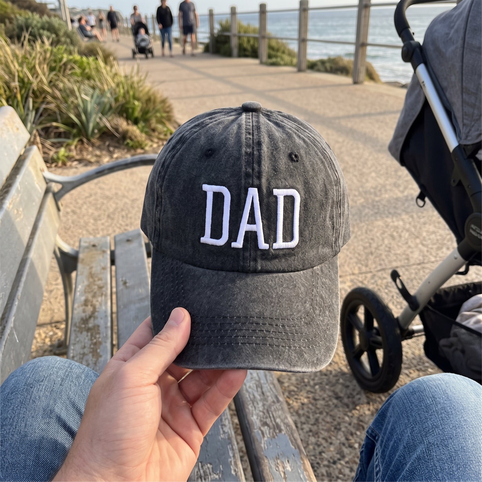Dad’s view of his Black DAD cap and a baby stroller on the coast