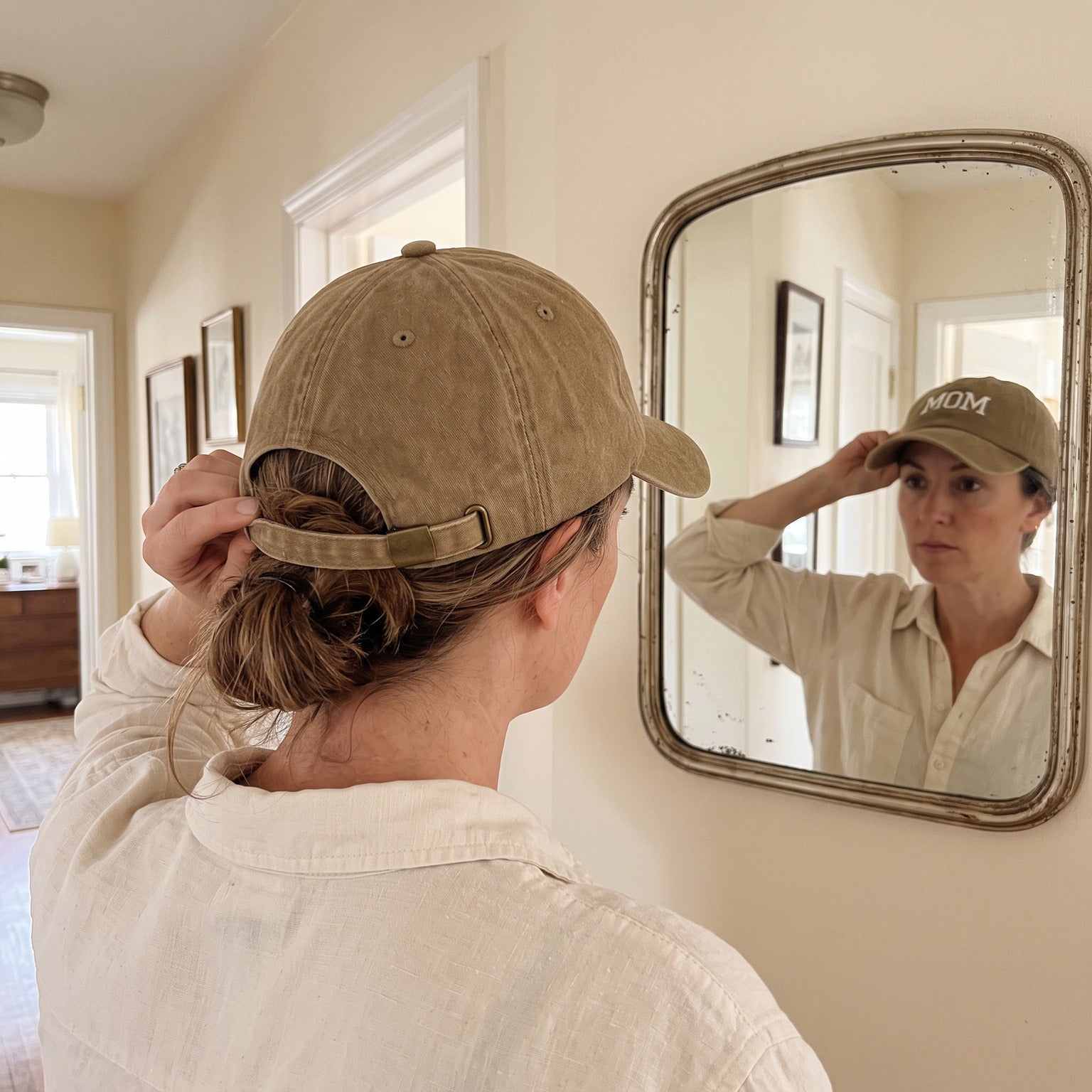 Mum adjusting her Khaki MOM cap in a hallway mirror